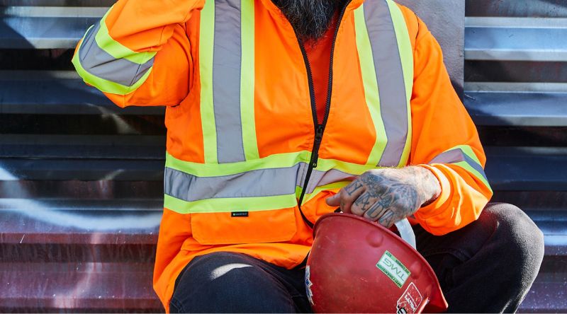 Construction worker wearing orange hi-vis overalls 